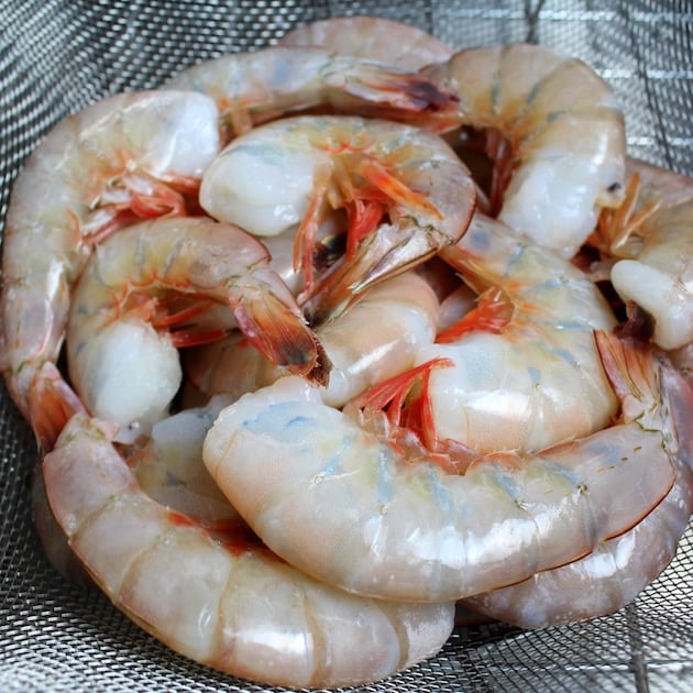 A close up of  shrimp in a strainer before cooking