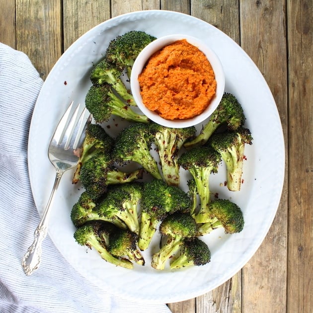 Grilled Broccoli on platter with ramekin of garlic red pepper sauce