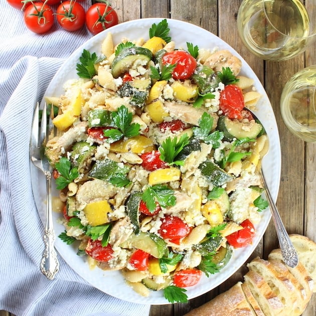 Grilled Chicken and Squash with Tomato Feta Pasta on serving platter with french bread and white wine