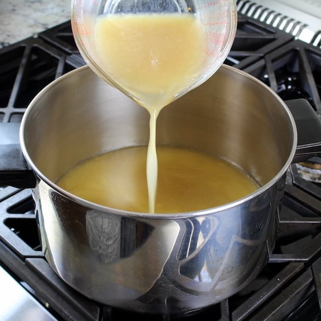 Adding chicken stock to pot