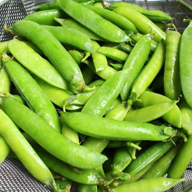 Peas in a wire strainer