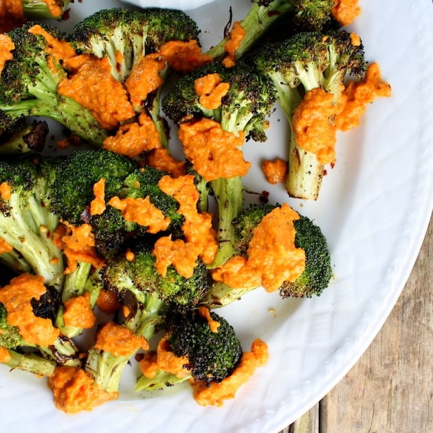 Grilled Broccoli florets with Garlic Roasted Red Pepper Sauce on white platter