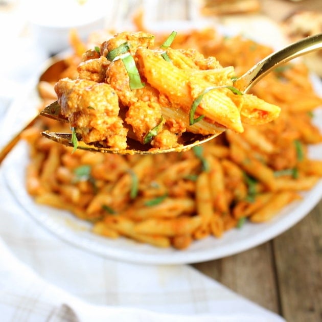 Spoon holding a bit of Spicy Chicken Pasta and Peas with Sun-Dried Tomato Sauce