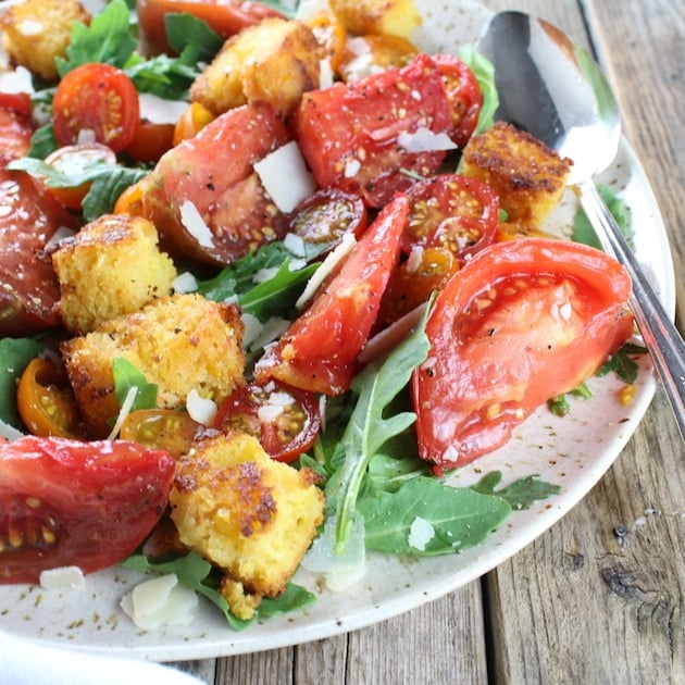 Eye level partial plate of heirloom tomato cornbread salad