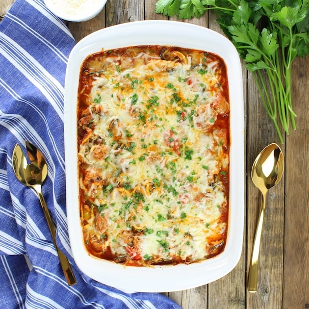 Sausage and Peppers with Zucchini Noodles in a casserole dish, topped with melted cheese