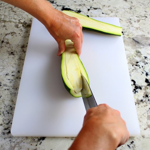 scraping out center of sliced squash