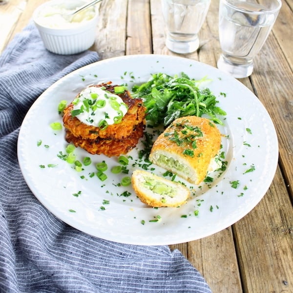 Breaded chicken cordon bleu on plate with potato cakes 