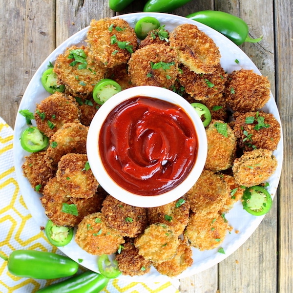 A plate of fried tables with spicy dipping ketchup on a farm table