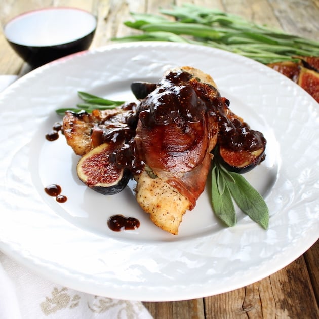 Chicken Fig Saltimbocca on a plate with glass of red wine