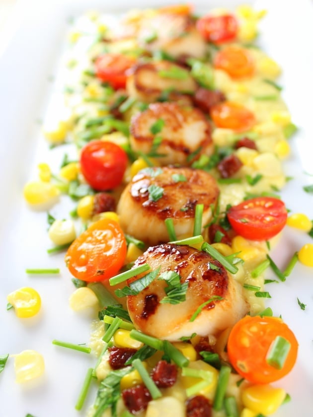 Eye level Close up of seared scallops on a bed of corn puree