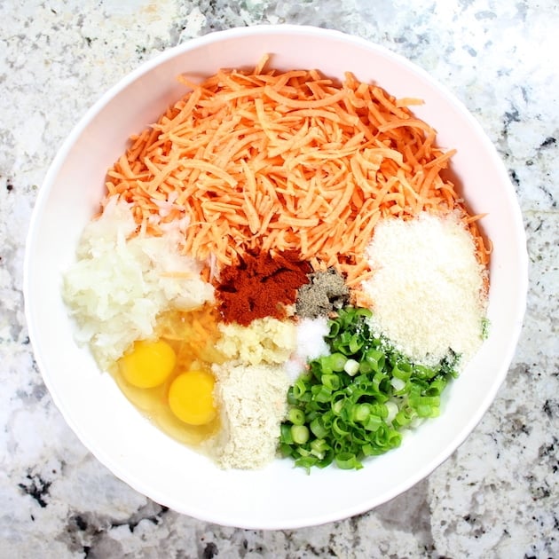 Large mixing bowl with ingredients for Parmesan Sweet Potato Cakes before combining