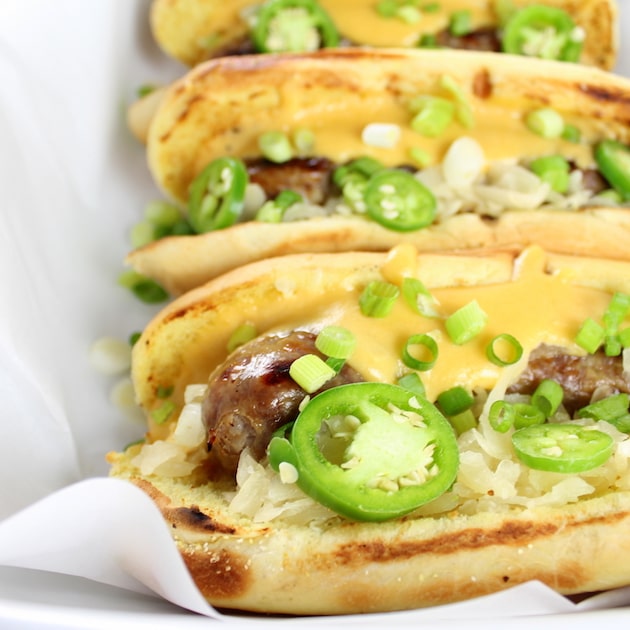 Eye level Cheesy Beer Brats with green onions and jalapenos