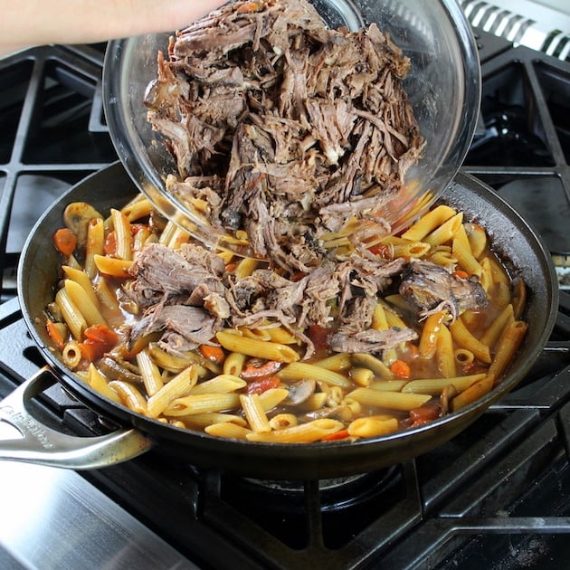 Adding pulled meat to Beef Ragu in saute pan