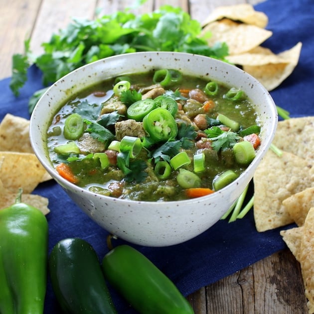 Bowl of Chicken and Green Chile Verde Soup surrounded by corn chips