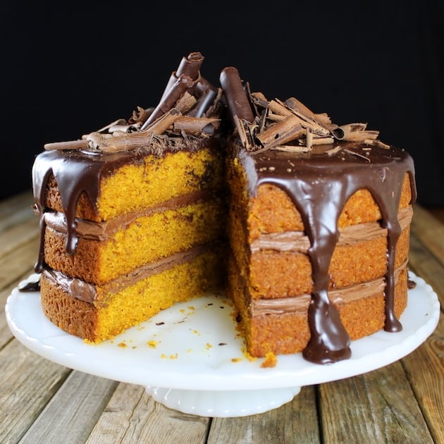 Pumpkin layer cake with chocolate ganache and shaved dark chocolate, with one slice removed