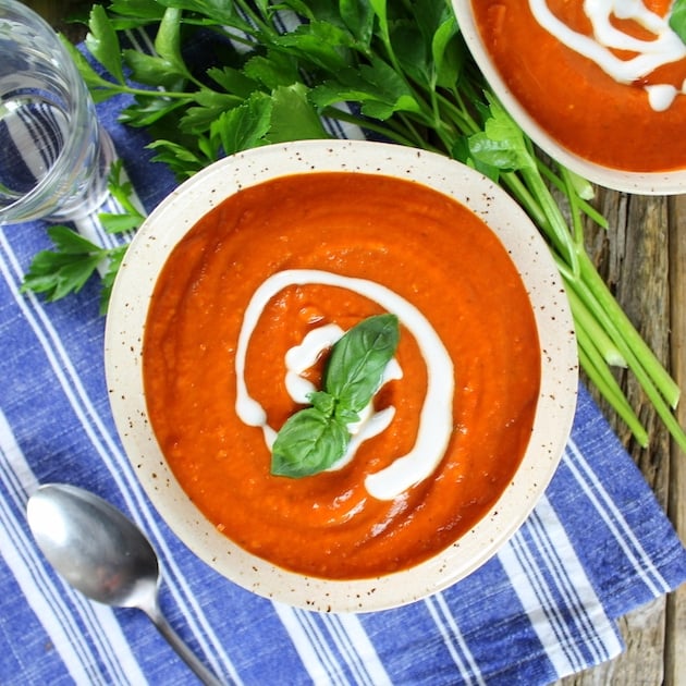 Two bowls of tomato soup with parsley garnish