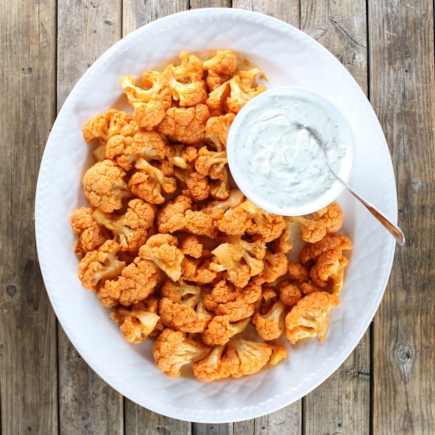 A platter of buffalo cauliflower sitting on top of a wooden table