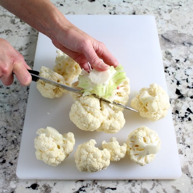 Cutting head of cauliflower on a cutting board