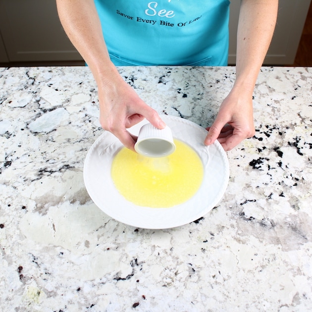 Adding garlic to plate with melted butter