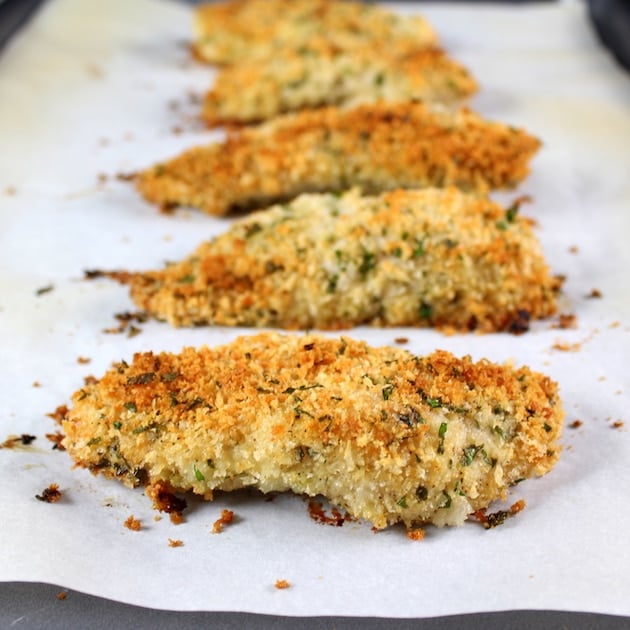 Parmesan Baked Chicken Strips on parchment paper after cooking