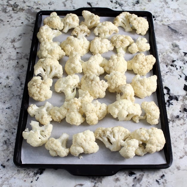 Cauliflower florets on a parchment-lined baking sheet