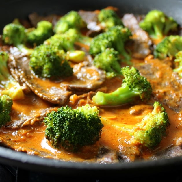 Eye level Broccoli and beef in saute pan with thai red ginger sauce