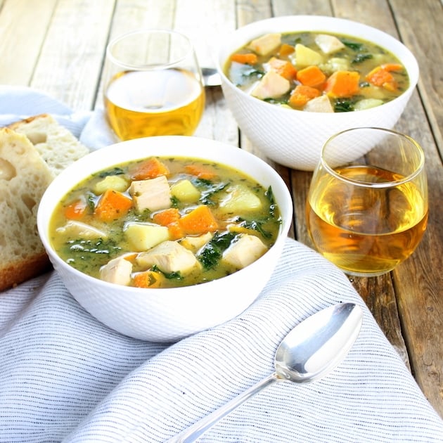 Two bowls of Kale and Butternut Squash Turkey Soup with wine glasses