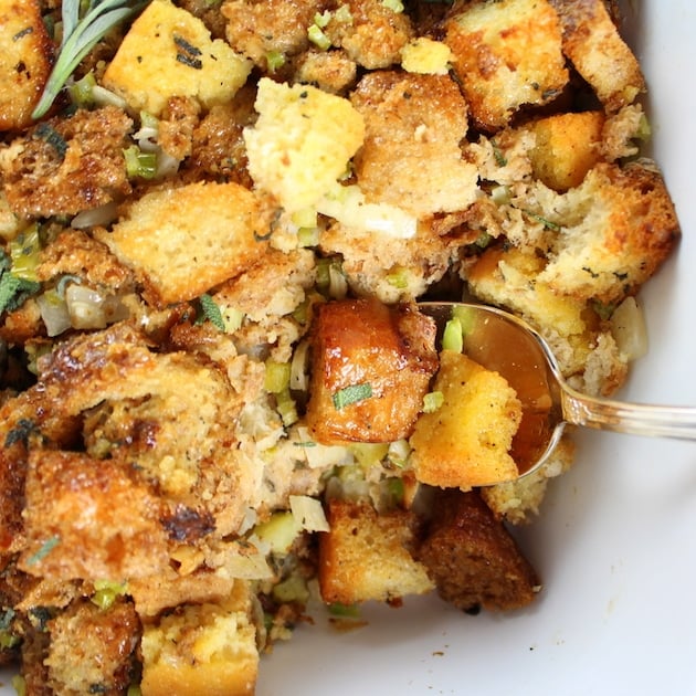 Spoon scooping Turkey Stuffing from casserole dish