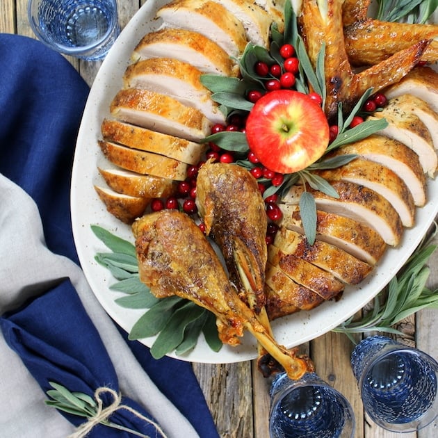 Thanksgiving Turkey carved on platter with blue glasses and napkins