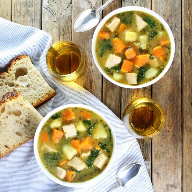 Two bowls of Kale and Butternut Squash Turkey Soup on farm table