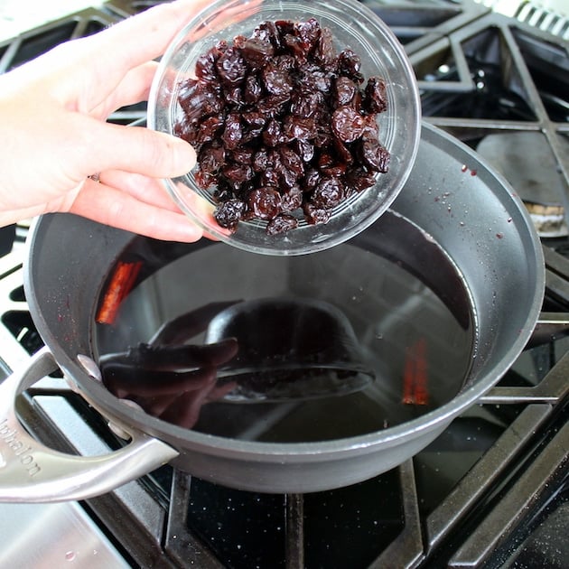 adding cherries to saucepan