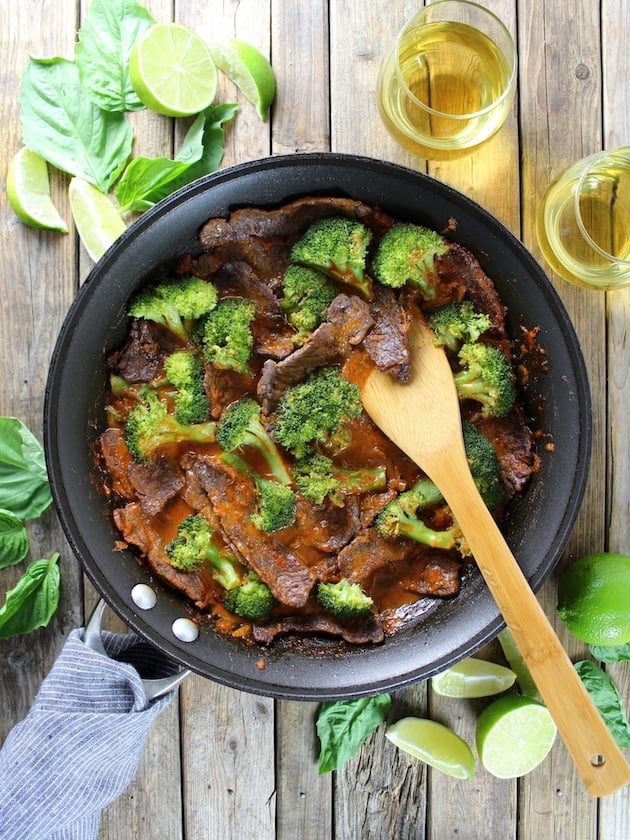 Thai Beef with Broccoli in pan with wine glasses