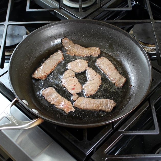 Thin beef slices frying in pan