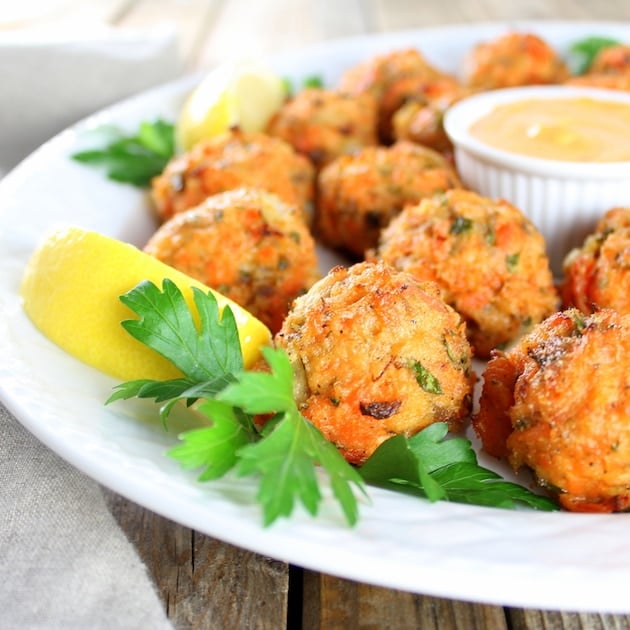 Eye-level view of salmon patties with Sriracha Lemon Aioli.