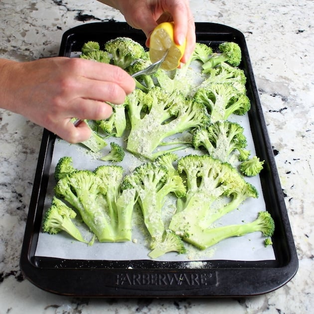 Squeezing lemon over broccoli before roasting
