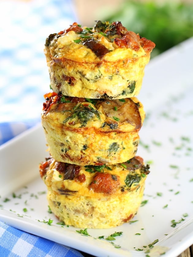 Three stacked breakfast \"egg cups\" with mushroom, kale, and spinach