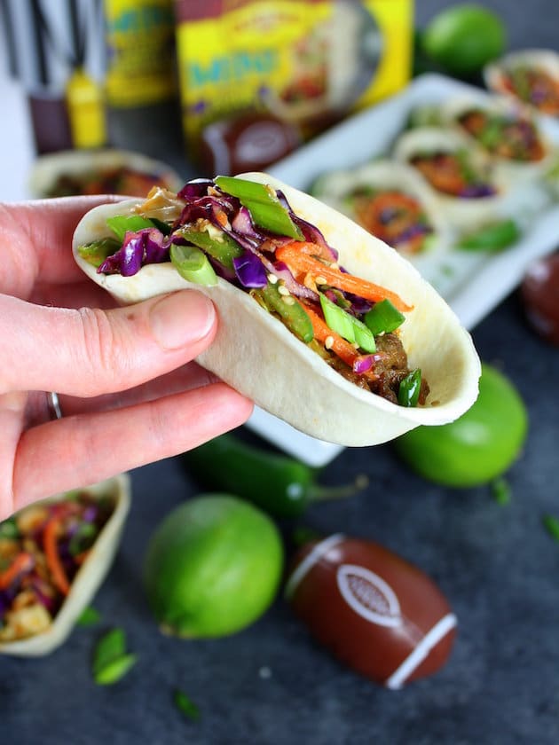 Hand holding a Korean Mini Taco Boat with Spicy Asian Slaw