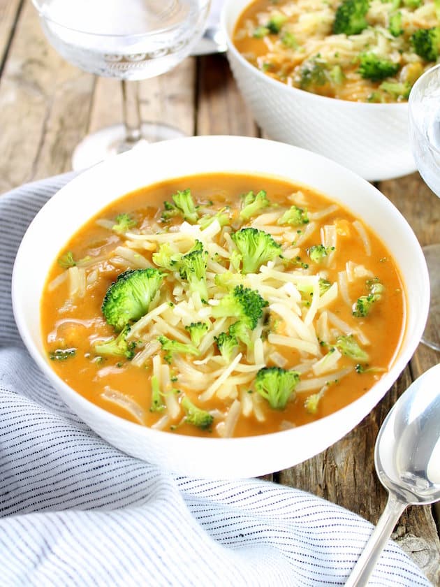 A bowl of food on a table, with Soup and Broccoli