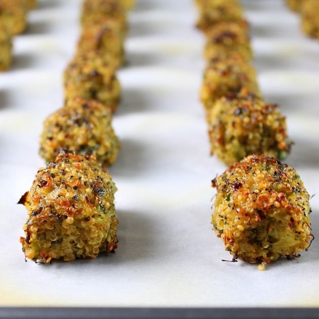 Baked Veggie Quinoa Tots lined up on parchment paper after cooking