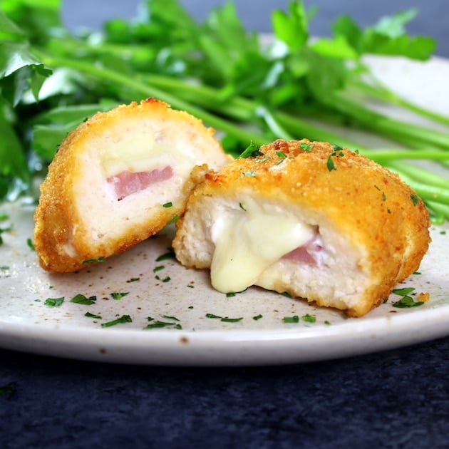 Breaded stuffed chicken sliced open with cheese oozing out