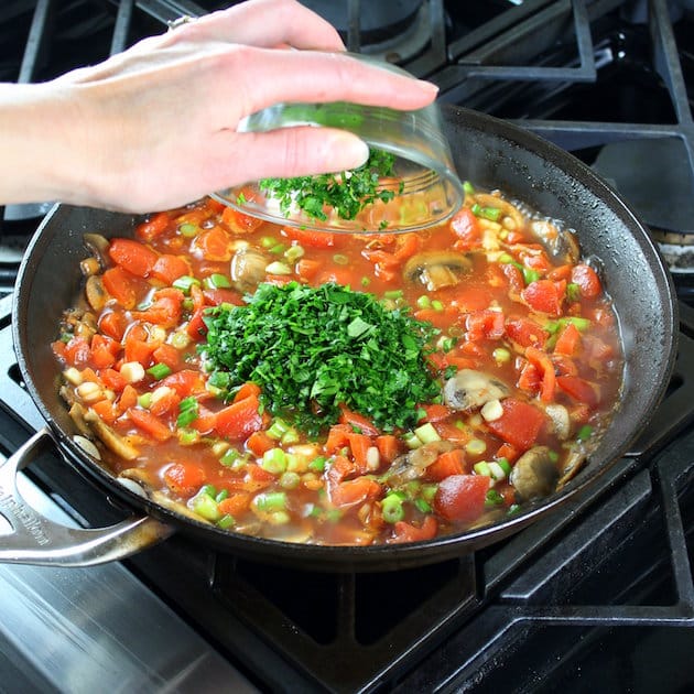Adding parsley to saute pan with italian sauce