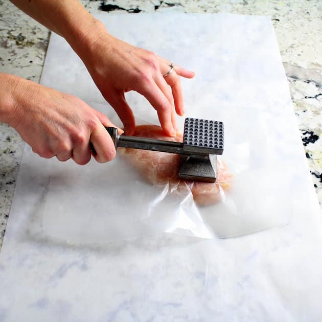 Flattening chicken breast with meat mallet