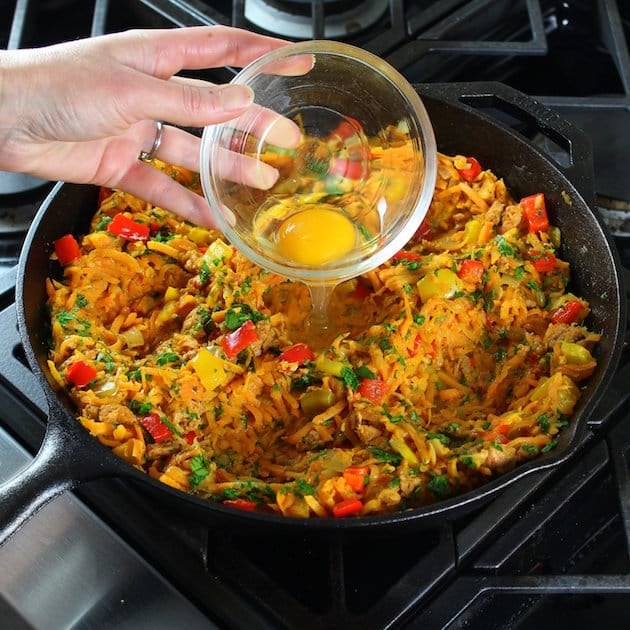 Adding eggs to breakfast skillet