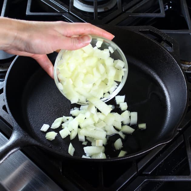 Adding chopped onions to a saute pan
