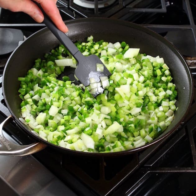 adding celery and carrots to skillet on stovetop