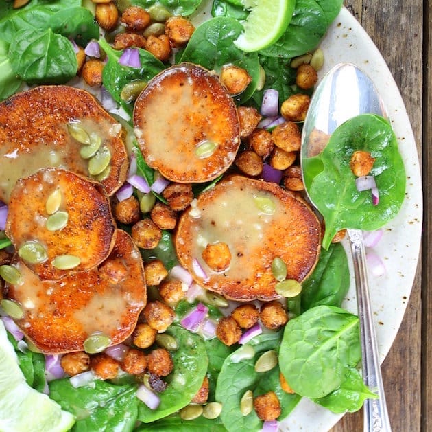 Partial plate of salad with sweet potatoes, chickpeas, and dressing