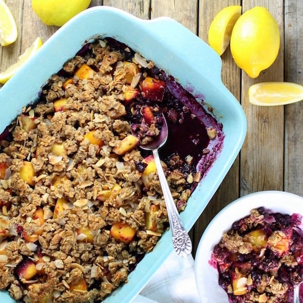 Blue baking dish with blueberry mango dessert topped with crumble mixture