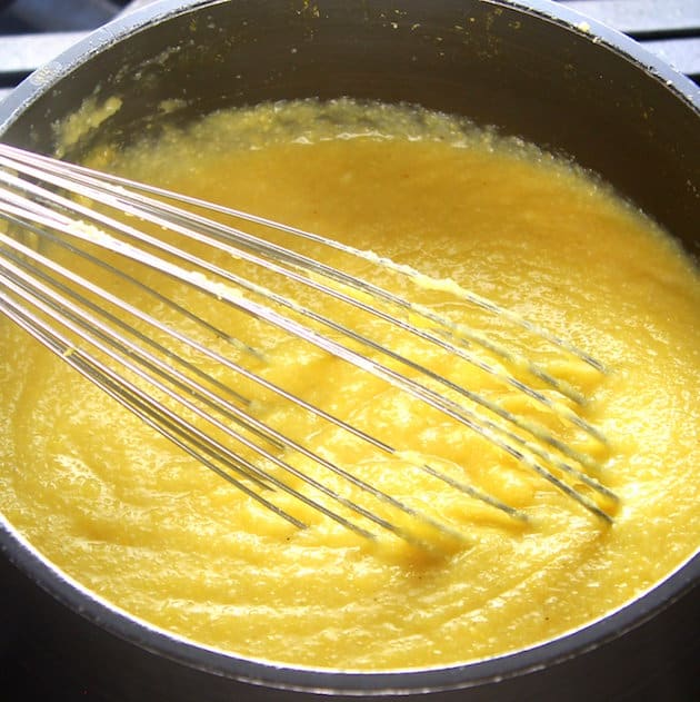 Whisk mixing polenta in a pot
