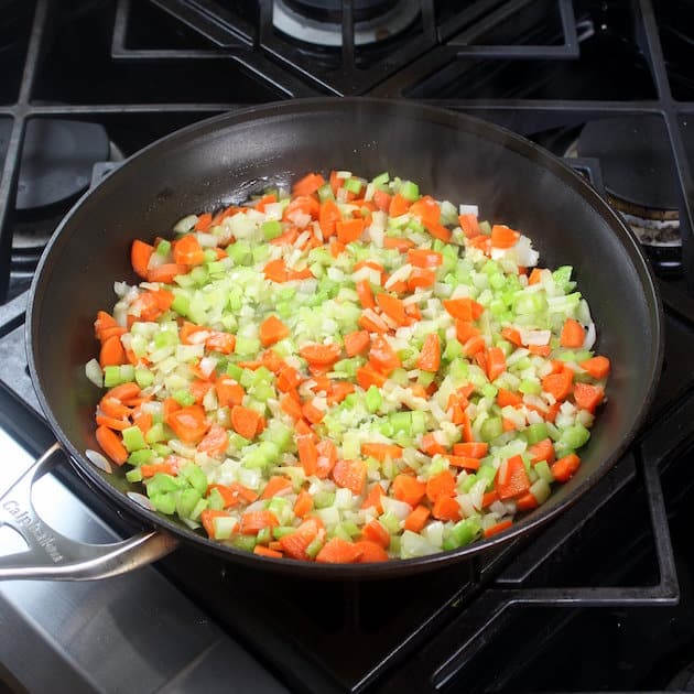 carrots, celery, and onion cooking in a pan