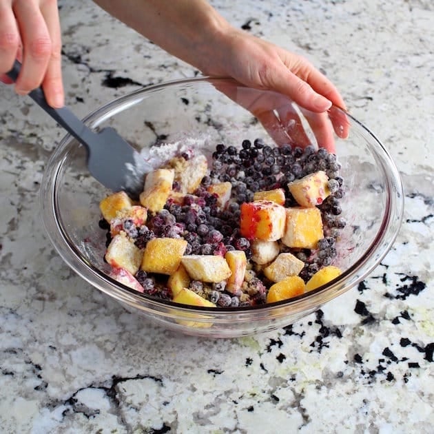 Mixing bowl with mangoes, blueberries, and coconut